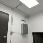 Panel and conduit in white room