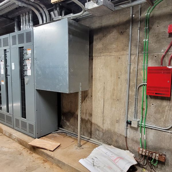 Red fire alarm conduit in an electrical room
